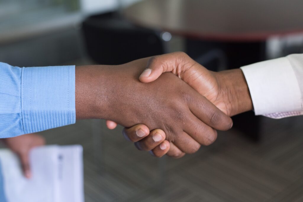 Financial advisor shaking hands with happy client after developing positive online reputation.