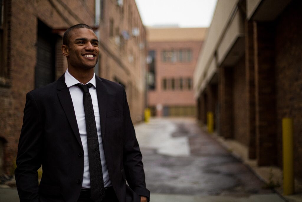 Financial advisor smiling, wearing suit, happily serving new generation of clients.